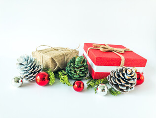 Arrangement of christmas ball ornaments, pine cones and pine branches with christmas present boxes on an isolated white surface with copy space