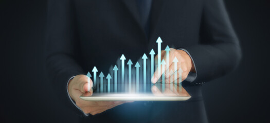 Graph growth and increase of chart positive indicators in his business,tablet in hand