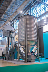 Grain store silo with discharge hopper - storage of agricultural food production at farming exhibition, trade show. Agriculture industry and automated technology equipment concept