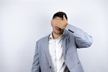 Business young man wearing a casual shirt over white background serious and covering her eyes with her hand