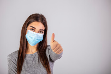 Portrait of young woman wearing face protective mask to prevent Coronavirus and anti-smog. Portrait of young woman wearing face mask. Thumb up.