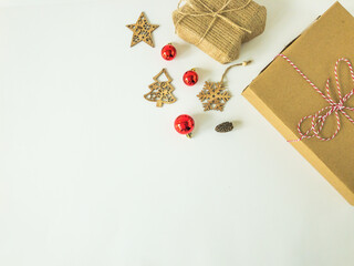 Christmas present boxes with wooden christmas ornaments, christmas ball ornaments and a pine cone on an isolated white surface, top view