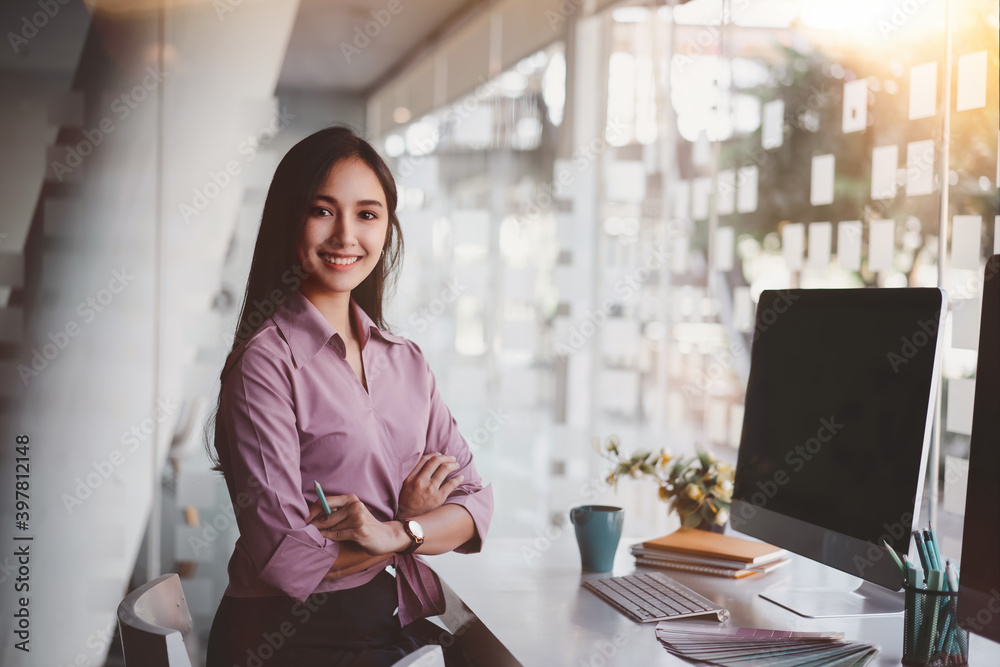 Wall mural beautiful confident asian business woman arms crossed and smiling at modern office background. indoo