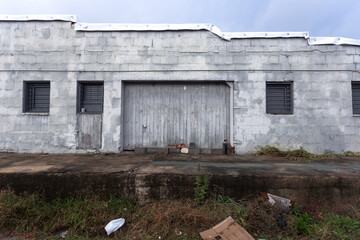 Side of vintage abandoned warehouse and freight door with sky in the deep south