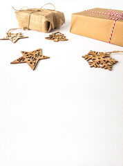 Wooden christmas ornaments with christmas present boxes on an isolated white surface with copy space, front view