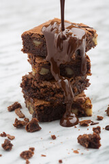 Delicious tower of classic chocolate brownies with walnuts and melted chocolate.