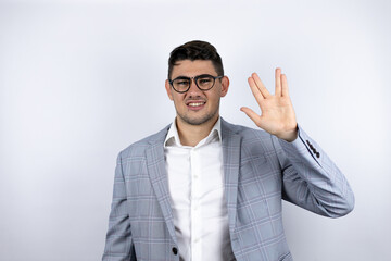 Business young man wearing a casual shirt over white background doing star trek freak symbol