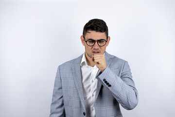 Business young man wearing a casual shirt over white background with his hand next to his mouth coughing
