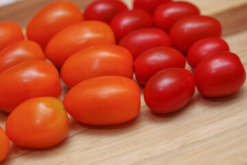 Yellow, orange and red kind of tomatoes on a wooden table