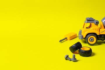 Construction machine concrete mixer made of plastic on a yellow background with a place for text...