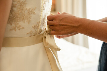 Trauzeugin verschließt Brautkleid der Braut