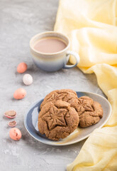 homemade oatmeal cookies with a cup of cocoa on a gray concrete background. side view, selective focus.
