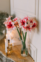 Beautiful flowers stand on the table near the candles in gold candlestick