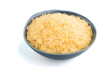 Blue ceramic bowl with raw golden rice isolated on white background. Side view.