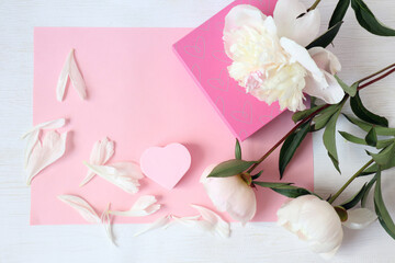 Gift with a picture-hearts, delicate peonies on a pink background, space for text, top view-the concept of congratulations on Valentine's day