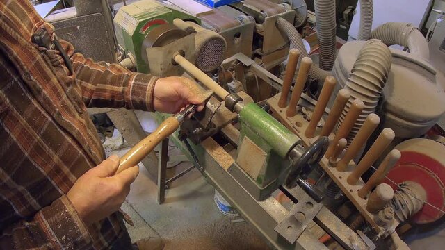 Making wooden dowel rod on turning wooden lathe with chisel; top view
