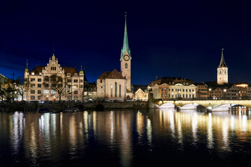 Fototapeta na wymiar Zürich Nachtaufnahme Stadthaus Kirchen Fraumünster und St. Peter Münsterbrücke Spiegelungen Fluss Limmat