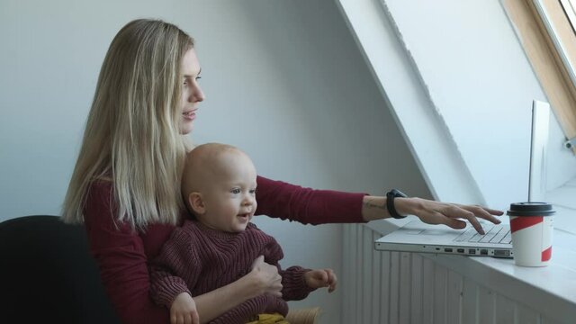 beautiful caucasian woman with toddler working at laptop