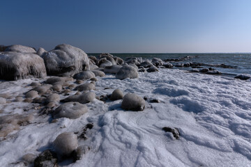 Rock groyne by Baltic Sea shore at dawn.