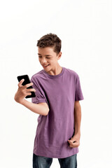 Teenaged disabled boy with cerebral palsy looking happy while holding and using smartphone, posing...
