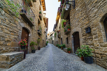Street of an old medieval town with stone houses and cobbled floors, street lamps and an atmosphere of bygone times.
 - obrazy, fototapety, plakaty