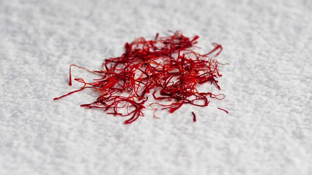 A pile of saffron threads, autumn crocuses, on the table with various spices. Saffron, red. Cooking ingredient. Twirling spices on a bright background. 4K
