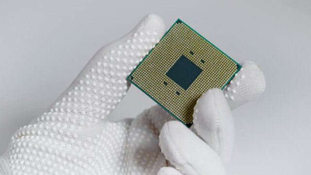 CPU. A laboratory technician holds a powerful processor in his hands. A group of scientists is working in the field of artificial intelligence.