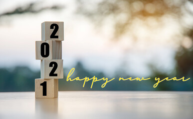 Vertical wooden cube with 2021 numbers, New Year's start date and Happy New Year letters.