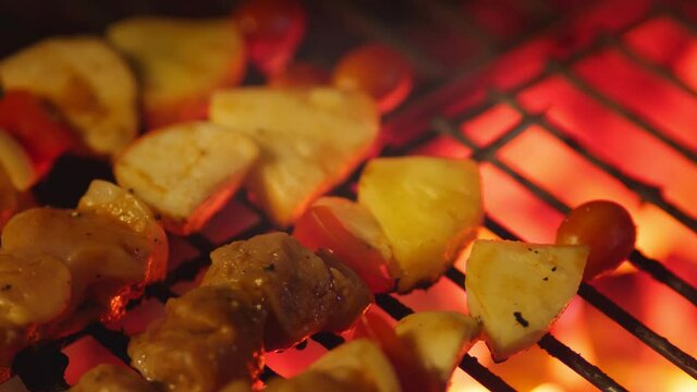 close up street vendor is grilling assorted BBQ meat and vegetable on bamboo skewers with sauce. Street food snack selling at traditional,meat and vegetables are cooked on the grill. BBQ grill.