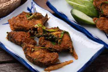 Stir fried catfish curry paste on wooden background.copy space