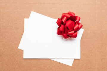 mock up blank white sheet with red bow on isolated background with place for text