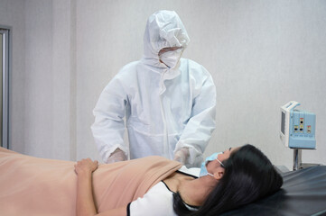 Doctor in medical ppe treating infected patient covid-19 in quarantine ward