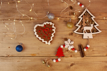 Christmas toys and gingerbread heart on a wooden table