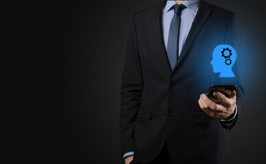 Businessman man holding a man icon with gears in his head. Artificial intelligence. Technology advances. Robot. Contour symbol.