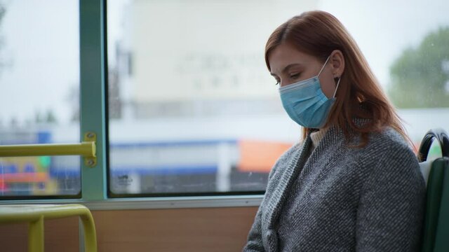 female passenger complies with modern safety standards and wears gloves and medical mask in public to protect against virus and infection while riding city bus