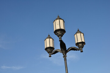 Fototapeta na wymiar rusticale street lamp from below upwards photographed against a blue sky