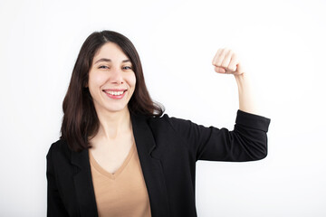 Young business woman standing on white isolated background Strong person showing arm muscle, confident.
