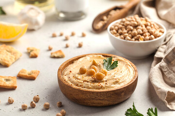 Hummus in a wooden plate with parsley and croutons. Dishes of chickpeas, a vegetarian dish.