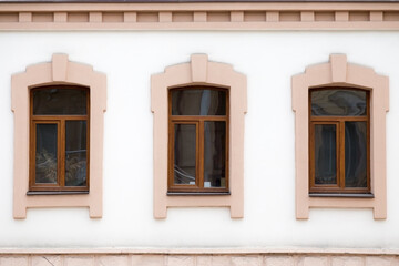 Three modern plastic windows in an old building.