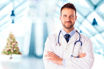 Male doctor standing in the hospital foyer at christmas time