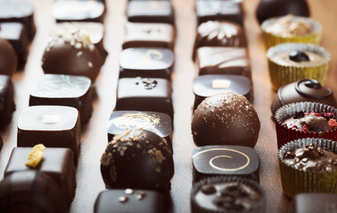 Mixed luxury dark and milk chocolate truffles. Assorted delicious handmade chocolate pralines in a row. Full frame background. Studio shot. Close-up