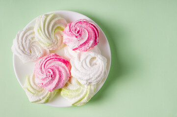 Obraz na płótnie Canvas Homemade sweet colored meringue on green background. .Dessert.