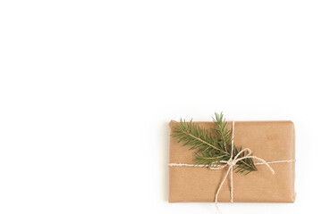 Gift box tied with a rope with a spruce branch on a white background.