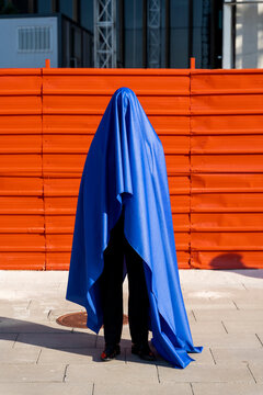 Anonymous man covered by blue cape
