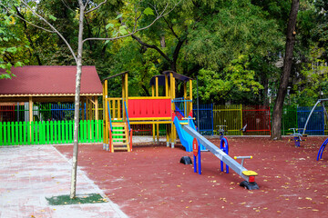 Colourful children playground with mixed plastic and metallic toys and materials in a sunny summer day in Bucharest, Romania .