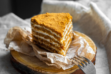 A piece of honey cakes, consisting of many layers and white sour cream. Homemade cake concept
