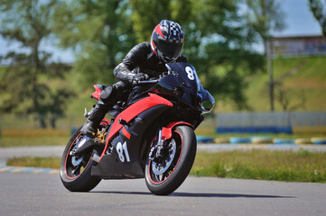 Road racing motorcykel in high speed into a curve, panning shot