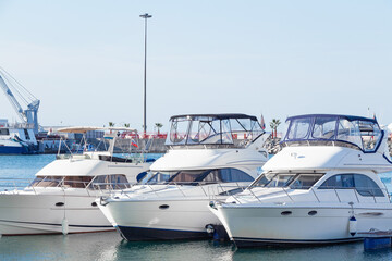 Fototapeta na wymiar White yachts in the port. Boats in the blue water harbor.