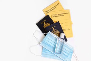 Two Canadian passports with yellow immunity vaccination records, face sanitary blue masks and...