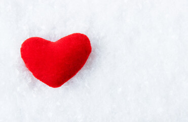 Bright red heart on a snowy, icy background. Copy space.
